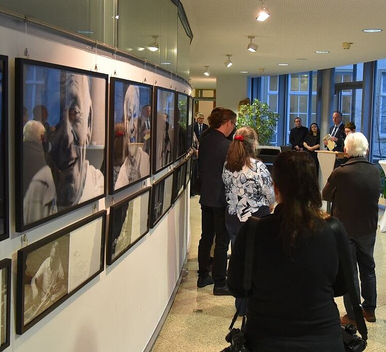 Gäste stehen vor den Fotos der Ausstellung