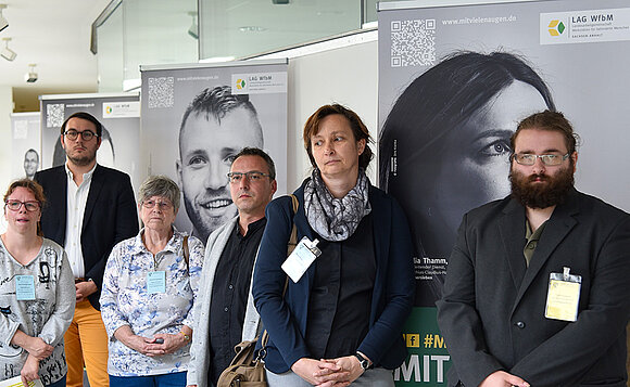 Gäste der Ausstellung stehen vor den Ausstellungsbannern